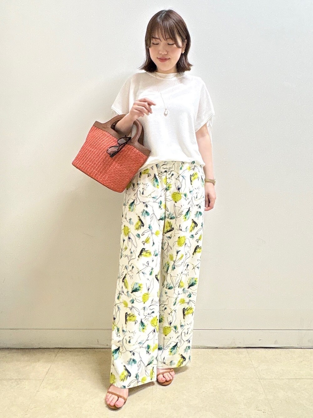 ホワイト系のニット/セーター、ベージュ系のその他パンツ、オレンジ系のショルダーバッグを着用したレディースの夏コーディネートの4枚目の写真