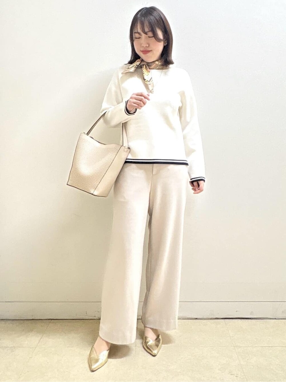 ベージュ系のその他パンツ、ホワイト系のニット/セーター、オレンジ系のカーディガン/ボレロを着用したレディースの冬コーディネートの4枚目の写真