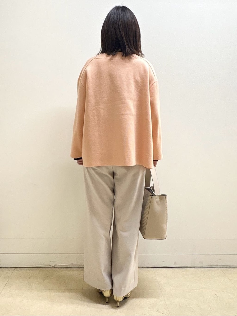 ベージュ系のその他パンツ、ホワイト系のニット/セーター、オレンジ系のカーディガン/ボレロを着用したレディースの冬コーディネートの9枚目の写真