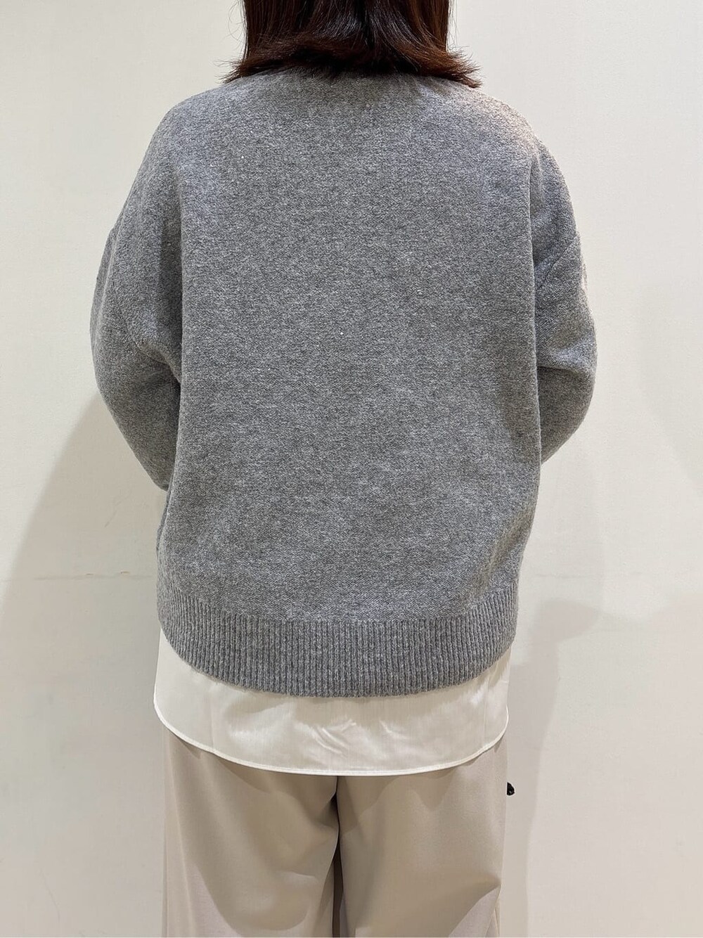 グレー系のニット/セーター、ホワイト系のTシャツ/カットソー、ベージュ系のその他パンツを着用したレディースの冬コーディネートの9枚目の写真