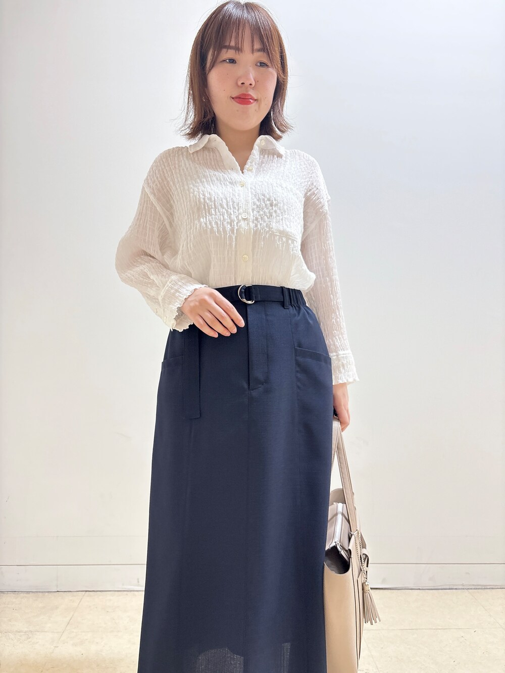 ホワイト系のシャツ/ブラウス、ブルー系のスカート、ベージュ系のトートバッグを着用したレディースの夏コーディネートの9枚目の写真