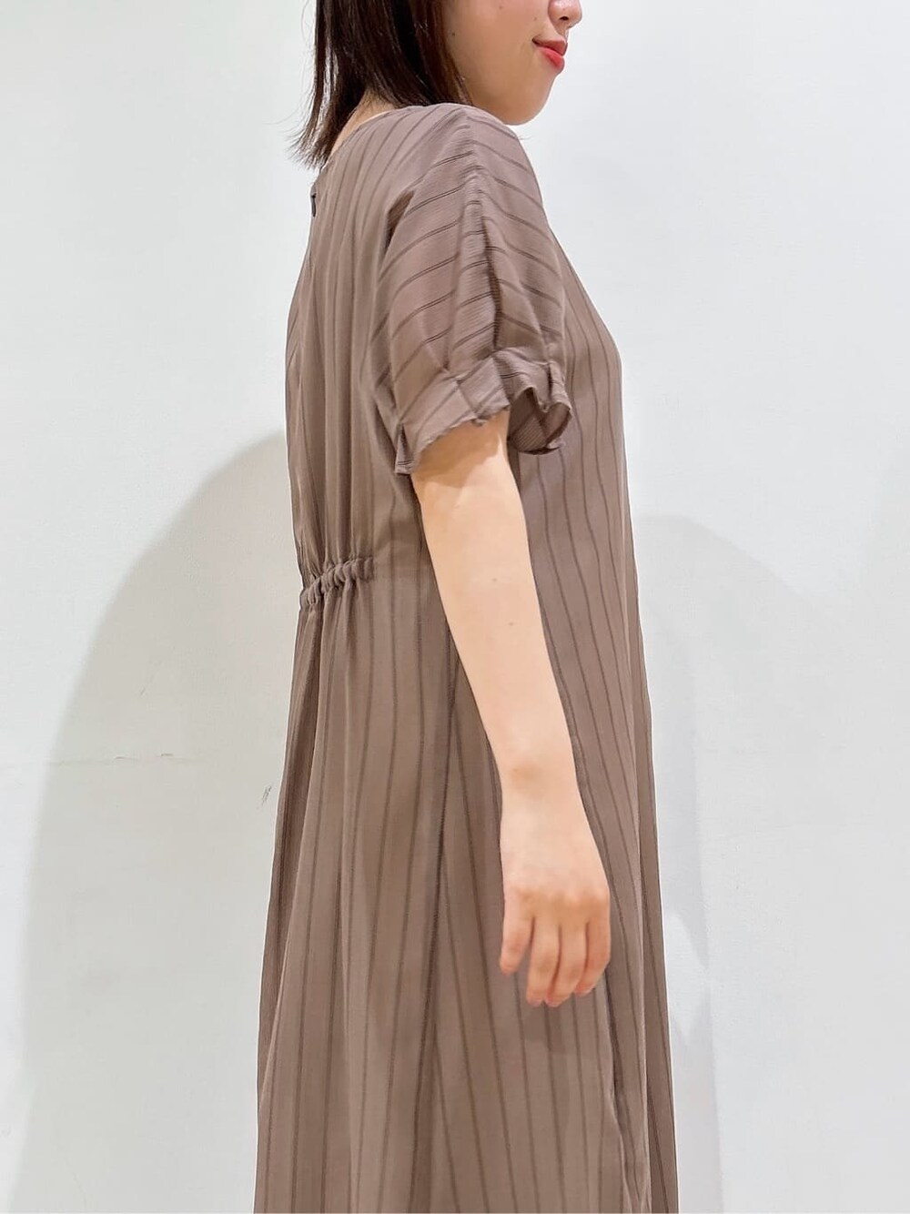 ブラウン系のワンピース、ブラック系のパンプス、ブラック系のハンドバッグを着用したレディースの夏コーディネートの9枚目の写真