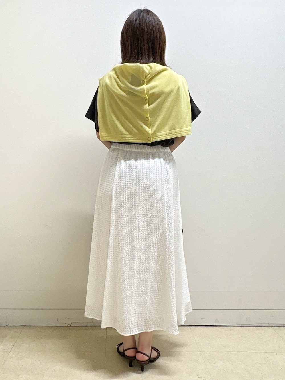 ブラウン系のTシャツ/カットソー、イエロー系のカーディガン/ボレロ、ホワイト系のスカートを着用したレディースの夏コーディネートの6枚目の写真