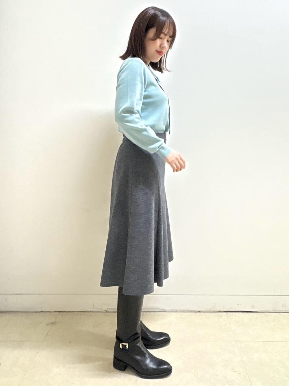 グレー系のダウンジャケット/コート、ブルー系のニット/セーター、グレー系のスカートを着用したレディースの秋コーディネートの8枚目の写真