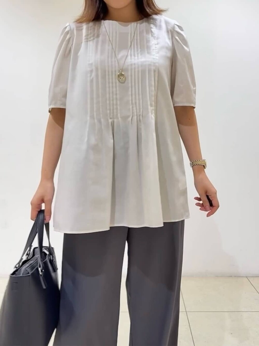 ベージュ系のシャツ/ブラウス、ベージュ系のパンプス、ブラック系のハンドバッグを着用したレディースの秋コーディネートの7枚目の写真
