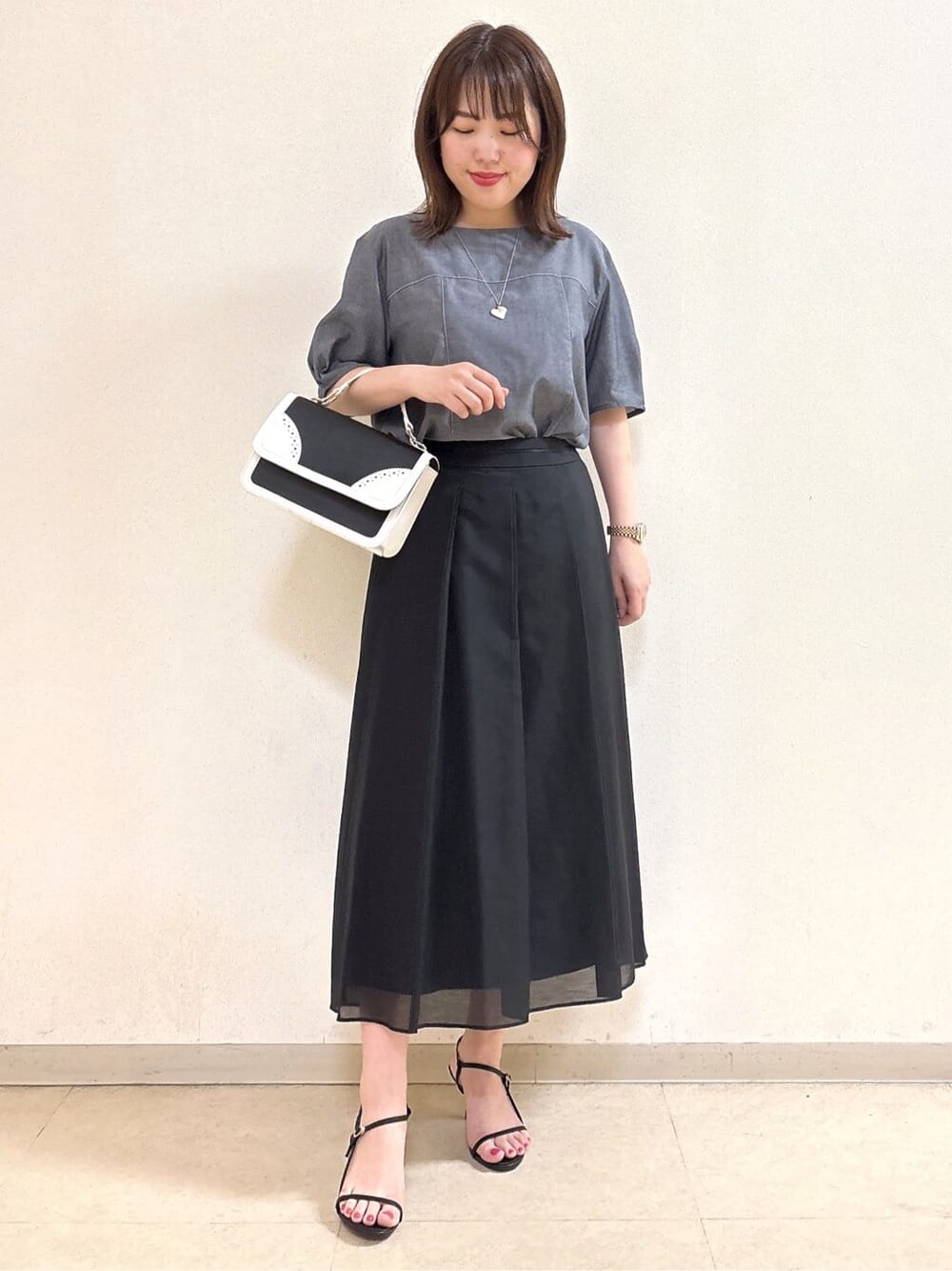 ブルー系のシャツ/ブラウス、ブラック系のスカート、ブラック系のショルダーバッグを着用したレディースの夏コーディネートの2枚目の写真