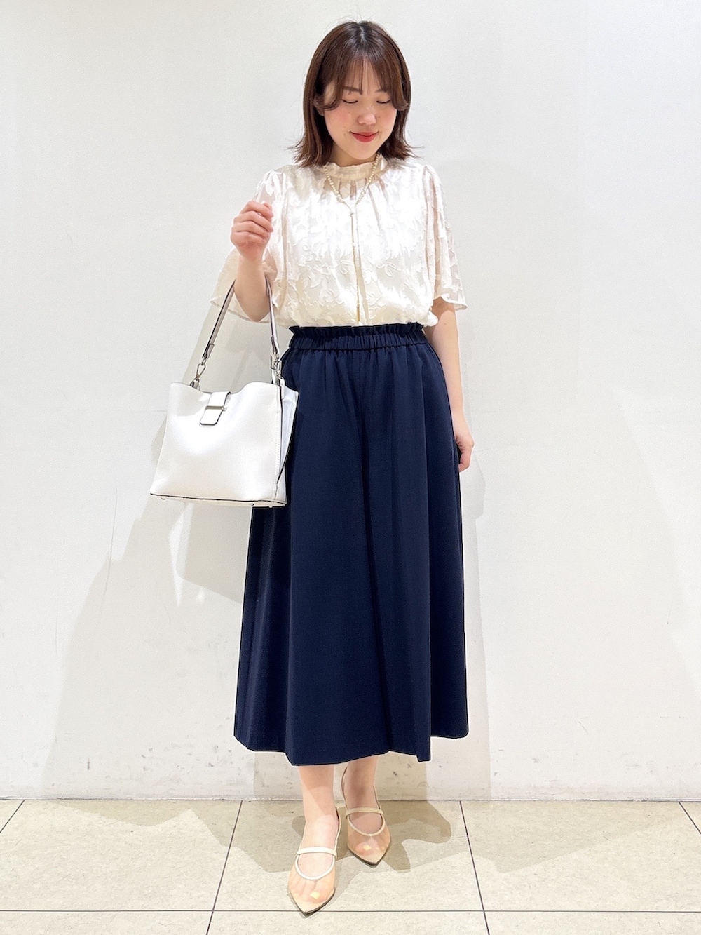 グレー系のノーカラージャケット、ホワイト系のトートバッグ、ブルー系のその他パンツを着用したレディースの春コーディネートの7枚目の写真