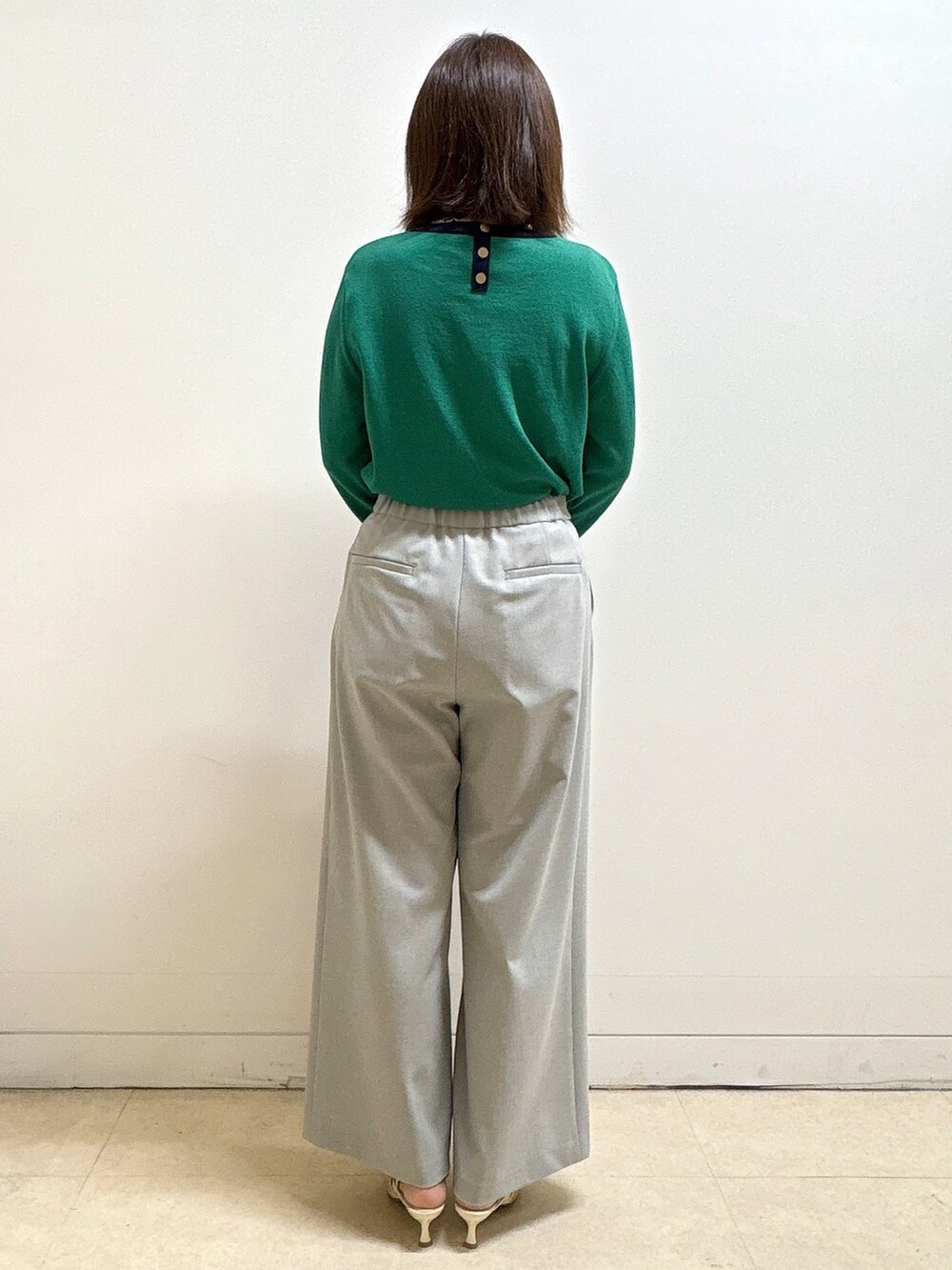 グレー系のその他パンツ、ブルー系のショルダーバッグ、グリーン系のニット/セーターを着用したレディースの春コーディネートの6枚目の写真