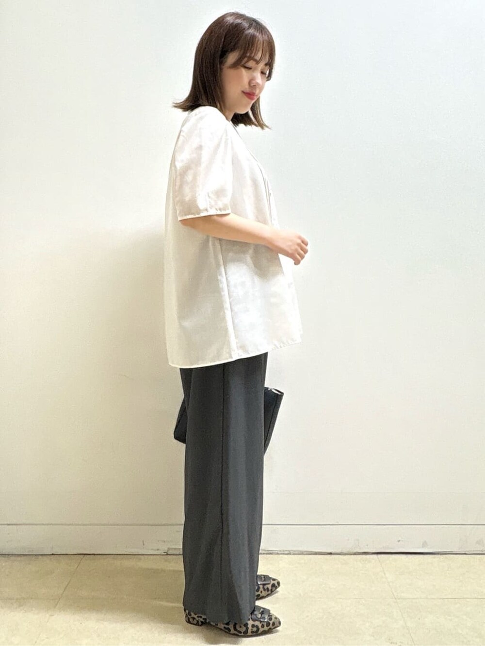 ベージュ系のシャツ/ブラウス、ベージュ系のパンプス、ブラック系のハンドバッグを着用したレディースの秋コーディネートの5枚目の写真