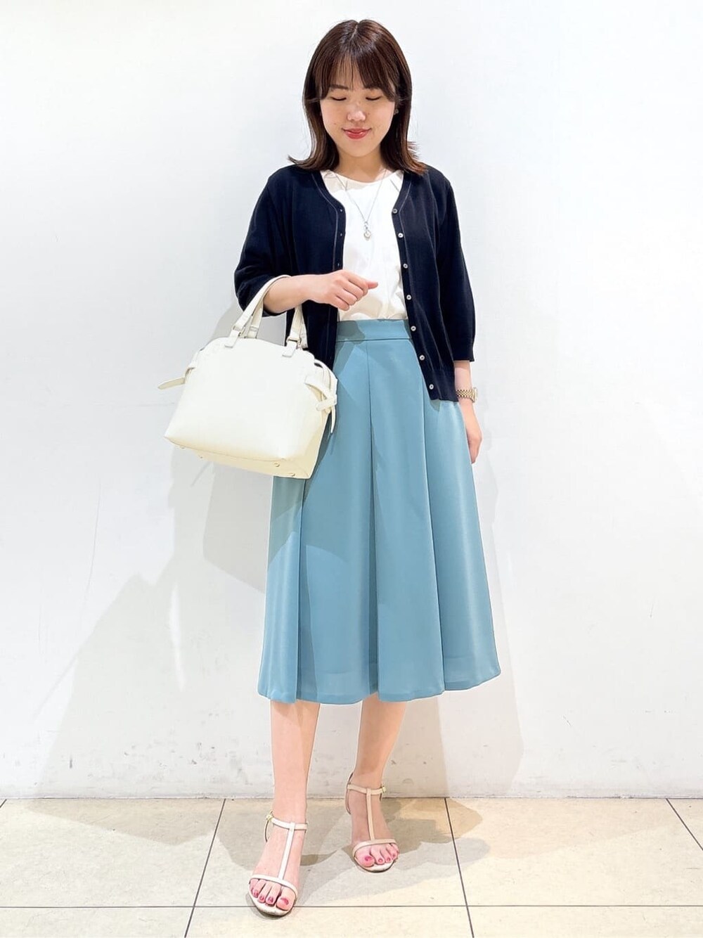 ブルー系のカーディガン/ボレロ、ホワイト系のTシャツ/カットソー、グリーン系のスカートを着用したレディースの夏コーディネートの4枚目の写真