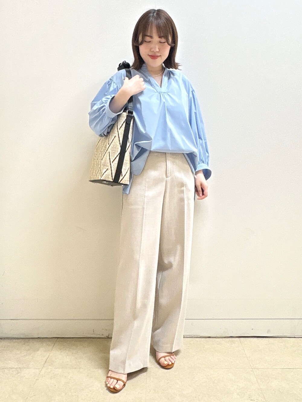 ベージュ系のショルダーバッグ、ブルー系のシャツ/ブラウス、ベージュ系のその他パンツを着用したレディースの春コーディネートの4枚目の写真