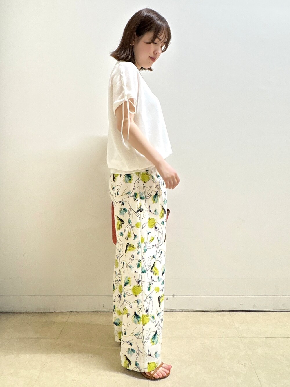 ホワイト系のニット/セーター、ベージュ系のその他パンツ、オレンジ系のショルダーバッグを着用したレディースの夏コーディネートの5枚目の写真