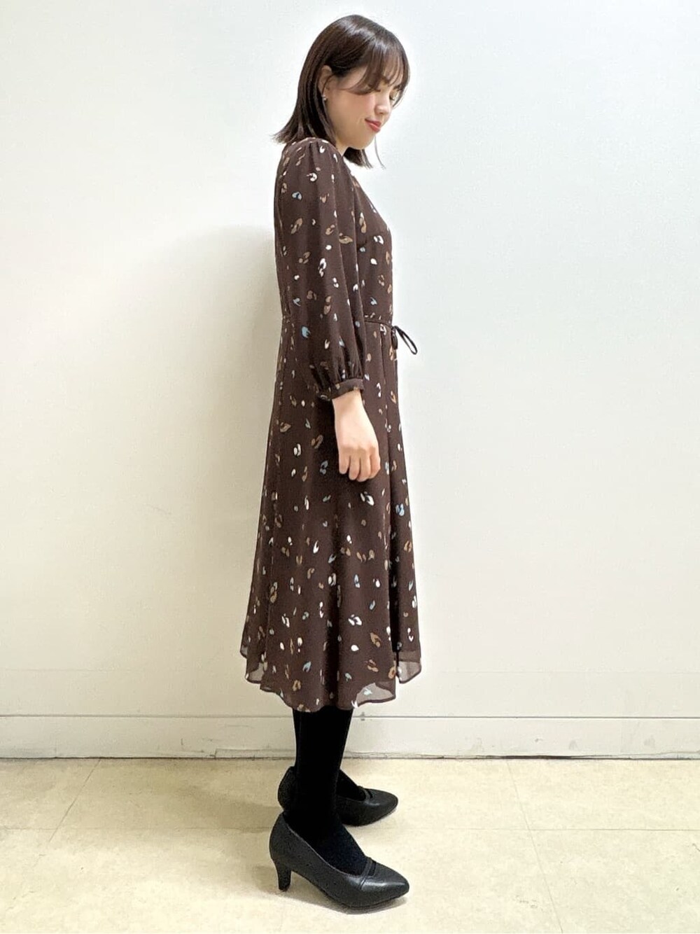ブルー系のカーディガン/ボレロ、ブラウン系のワンピース、ブラック系のパンプスを着用したレディースの冬コーディネートの8枚目の写真