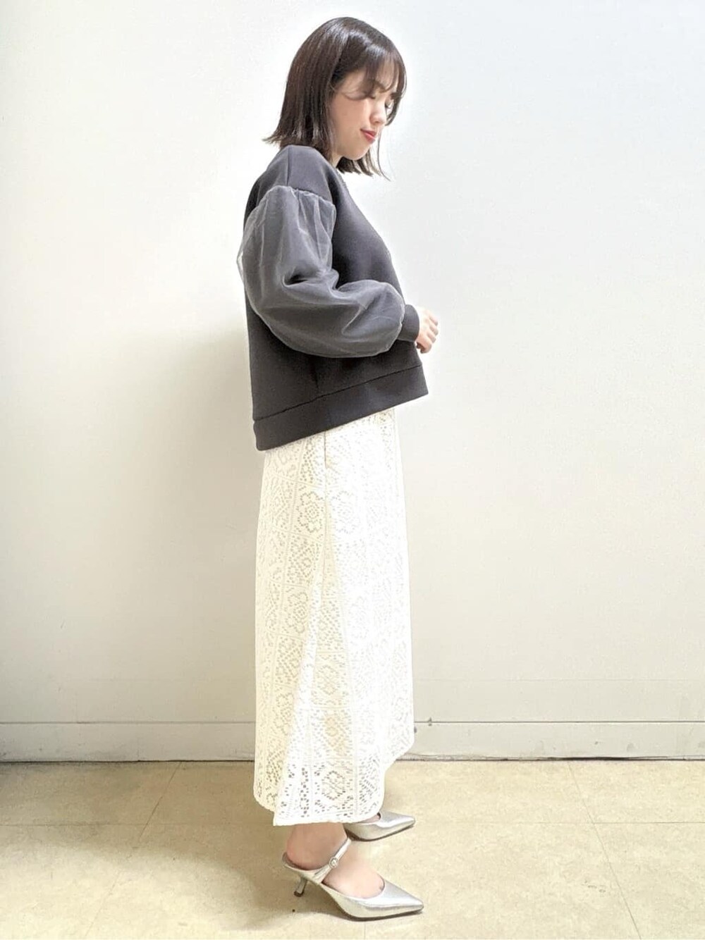 ホワイト系のスカート、グレー系のTシャツ/カットソー、イエロー系のショルダーバッグを着用したレディースの冬コーディネートの5枚目の写真