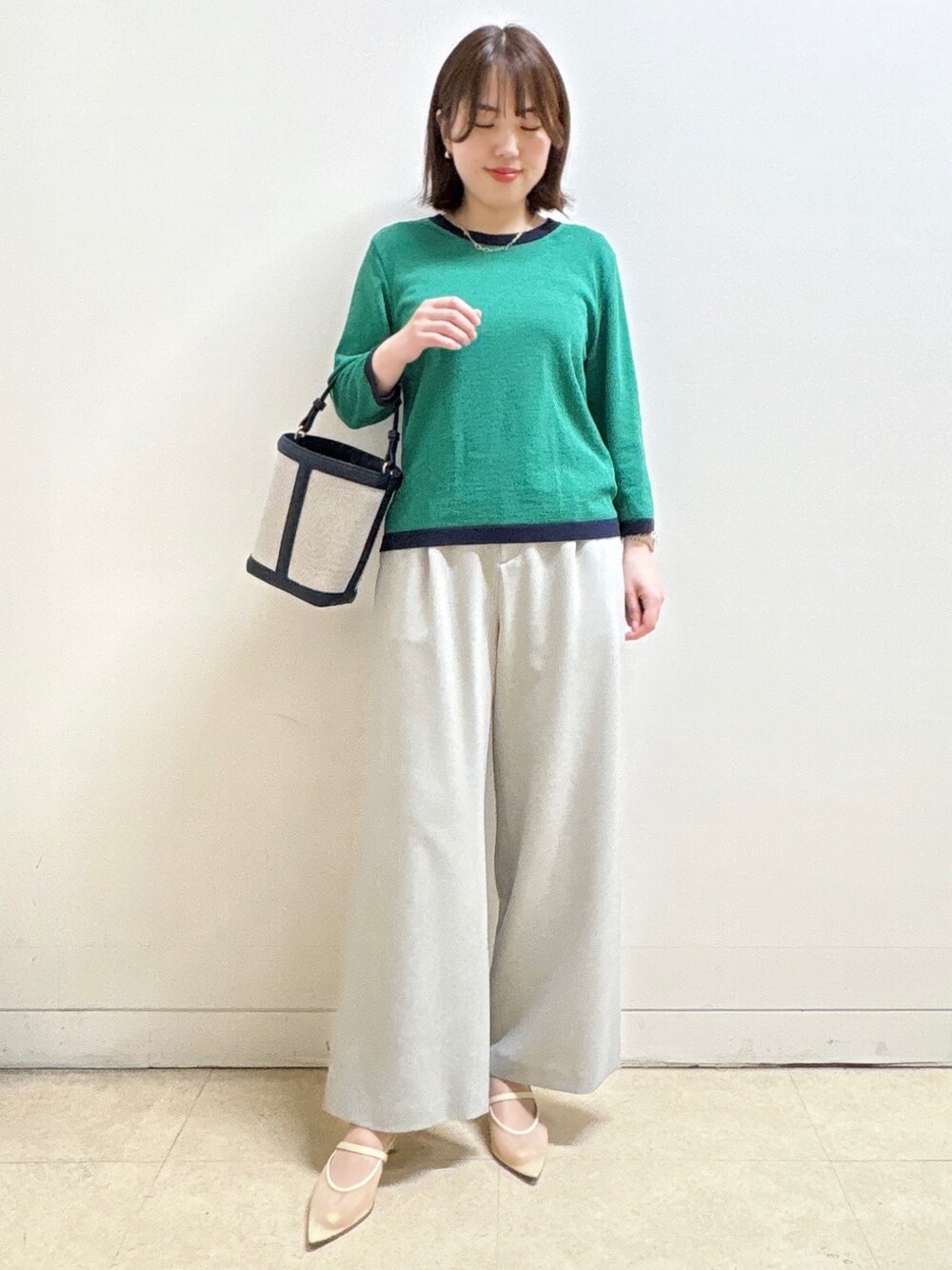 グレー系のその他パンツ、ブルー系のショルダーバッグ、グリーン系のニット/セーターを着用したレディースの春コーディネートの7枚目の写真