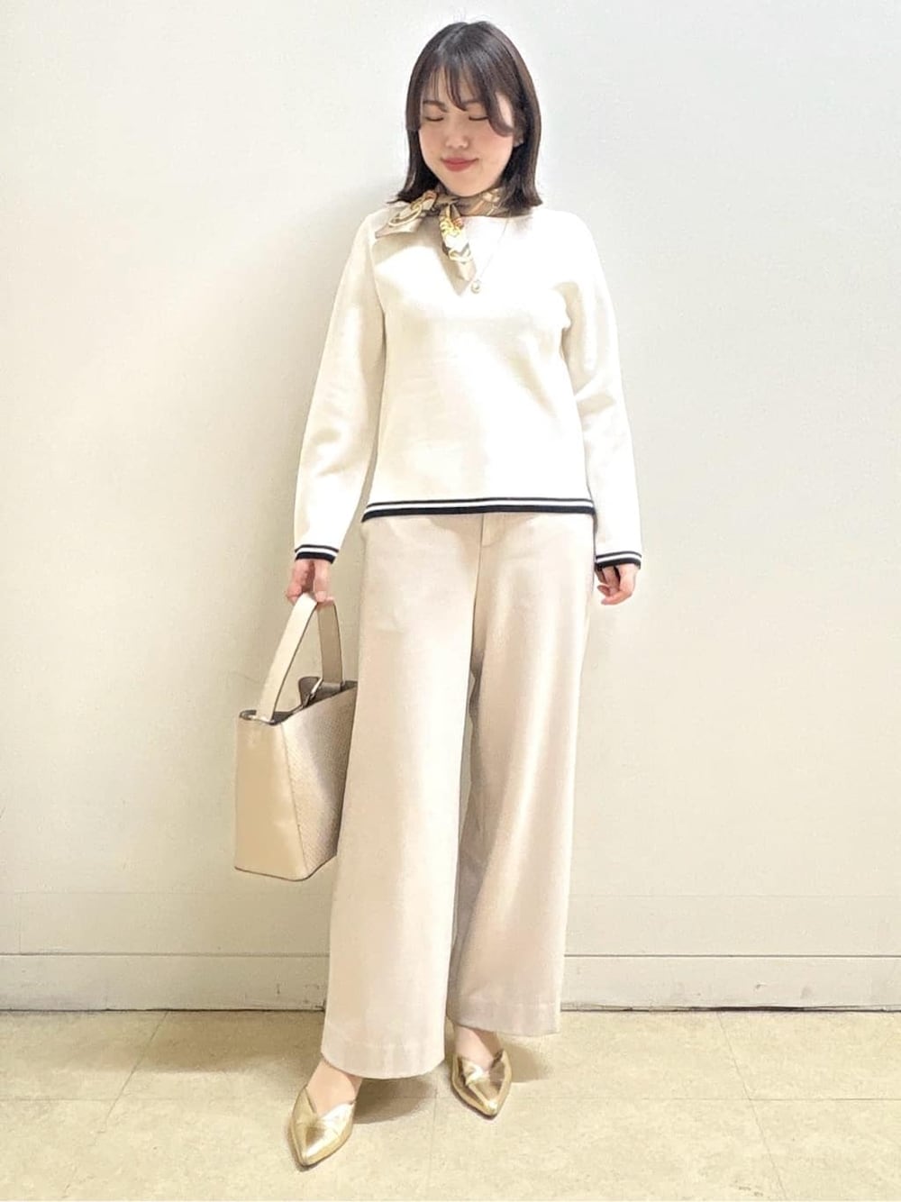 ベージュ系のその他パンツ、ホワイト系のニット/セーター、オレンジ系のカーディガン/ボレロを着用したレディースの冬コーディネートの3枚目の写真