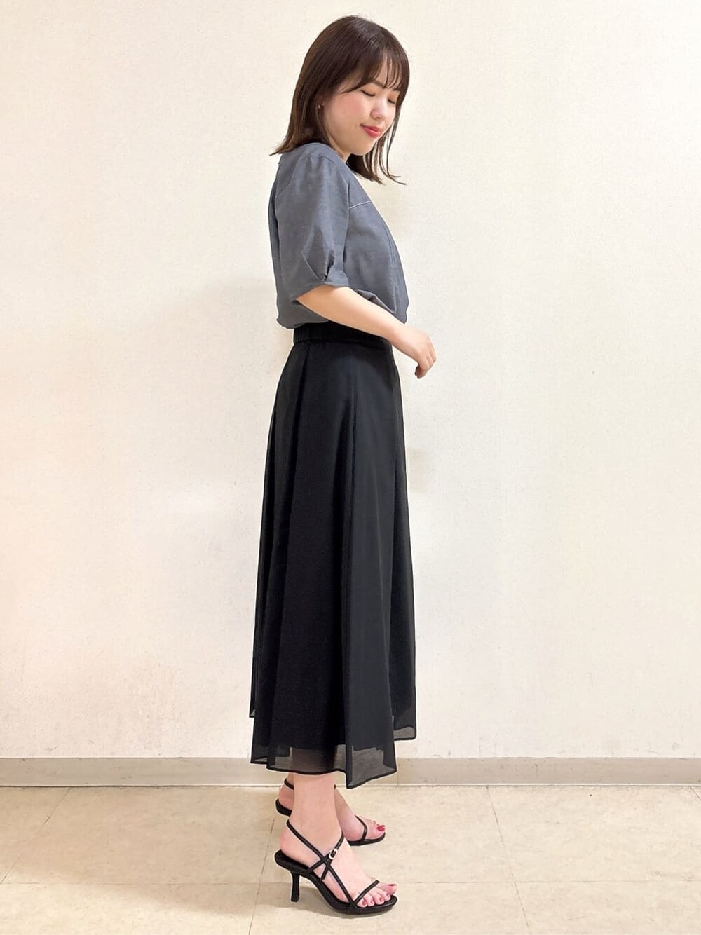 ブルー系のシャツ/ブラウス、ブラック系のスカート、ブラック系のショルダーバッグを着用したレディースの夏コーディネートの5枚目の写真