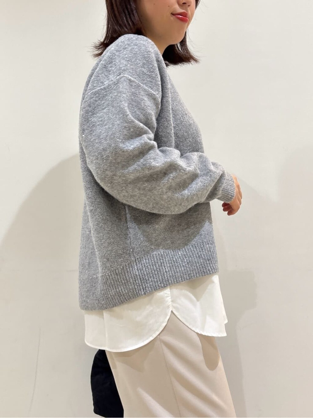 グレー系のニット/セーター、ホワイト系のTシャツ/カットソー、ベージュ系のその他パンツを着用したレディースの冬コーディネートの8枚目の写真