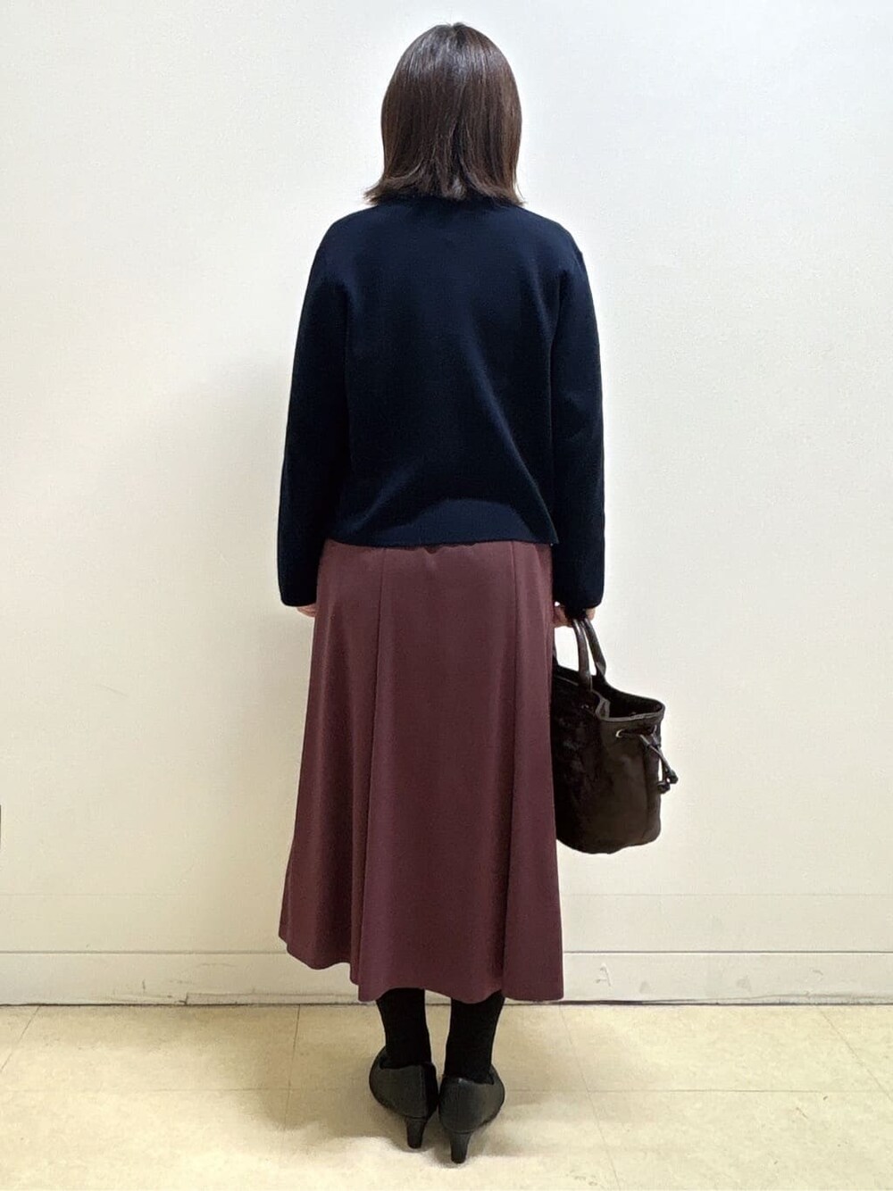 ブルー系のカーディガン/ボレロ、ブルー系のシャツ/ブラウス、レッド系のスカートを着用したレディースの冬コーディネートの5枚目の写真