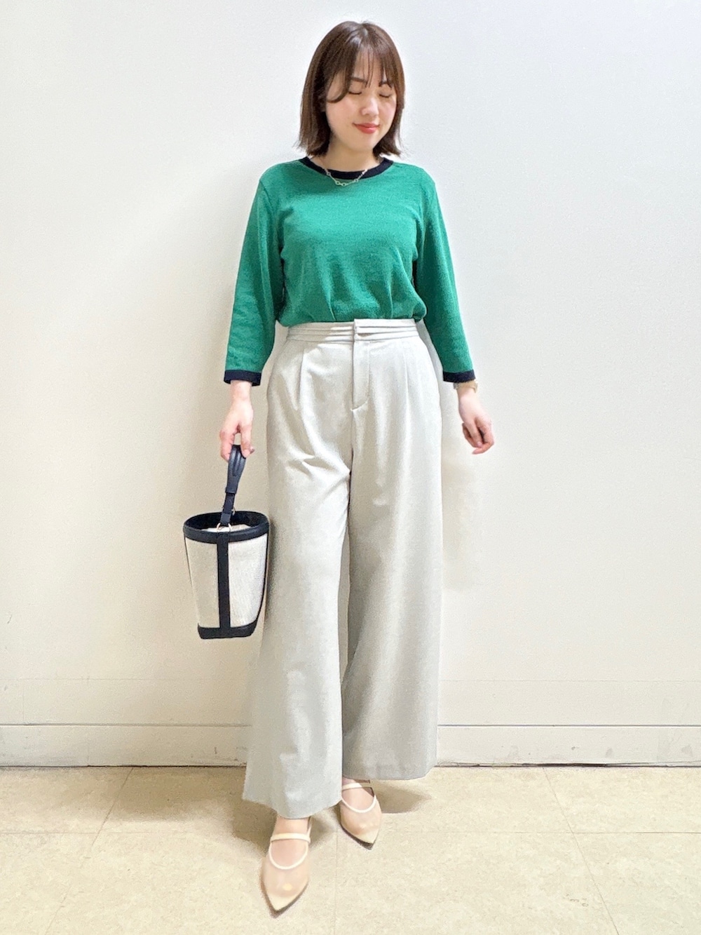 グレー系のその他パンツ、ブルー系のショルダーバッグ、グリーン系のニット/セーターを着用したレディースの春コーディネートの2枚目の写真
