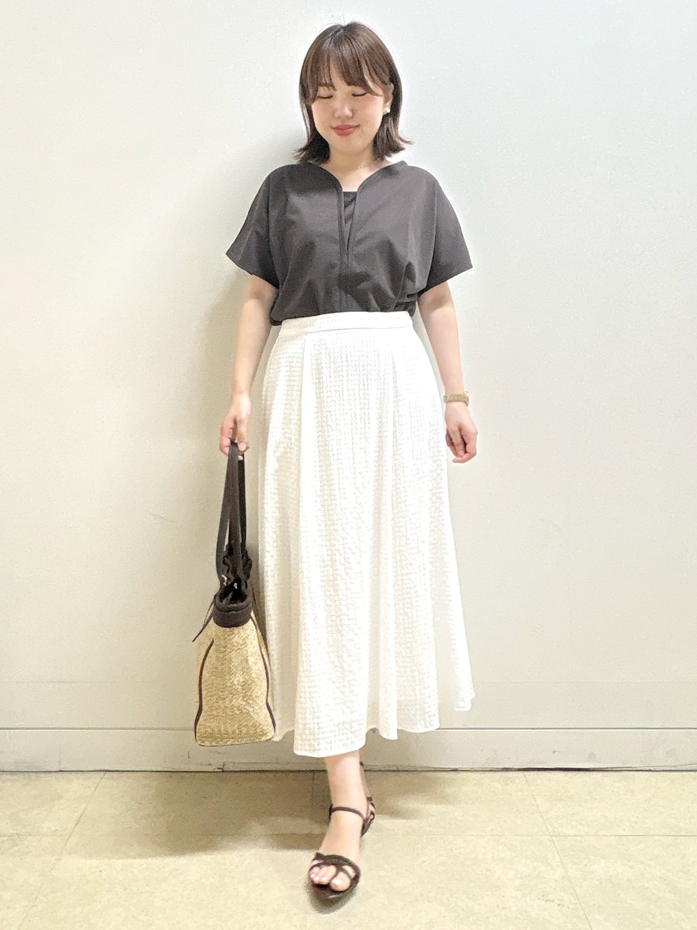 ブラウン系のTシャツ/カットソー、イエロー系のカーディガン/ボレロ、ホワイト系のスカートを着用したレディースの夏コーディネートの7枚目の写真