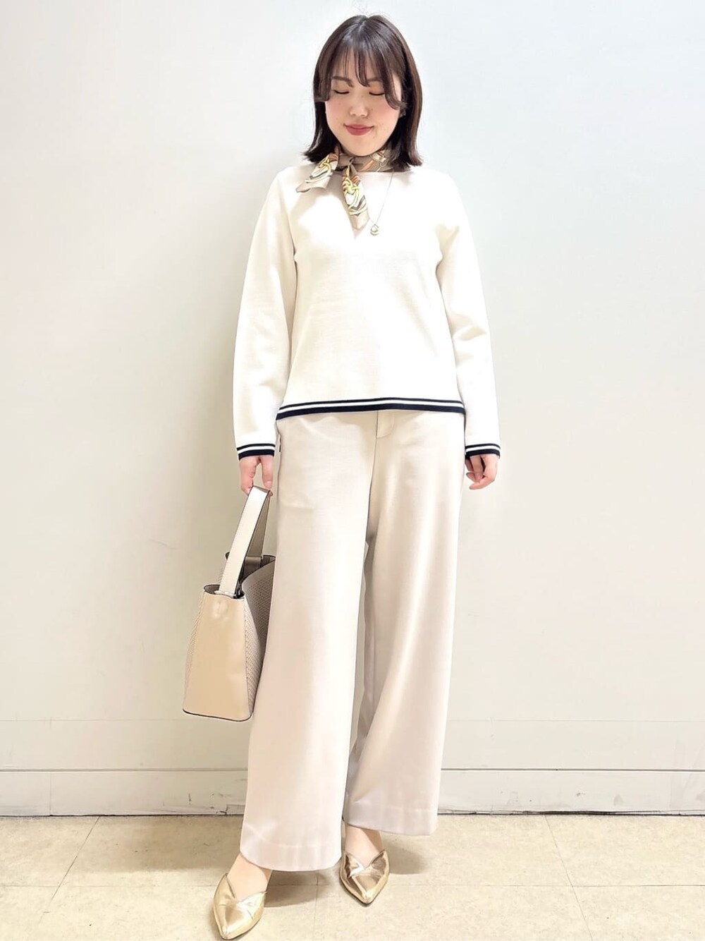 ホワイト系のニット/セーター、ベージュ系のその他パンツ、ベージュ系のショルダーバッグを着用したレディースの冬コーディネートの2枚目の写真