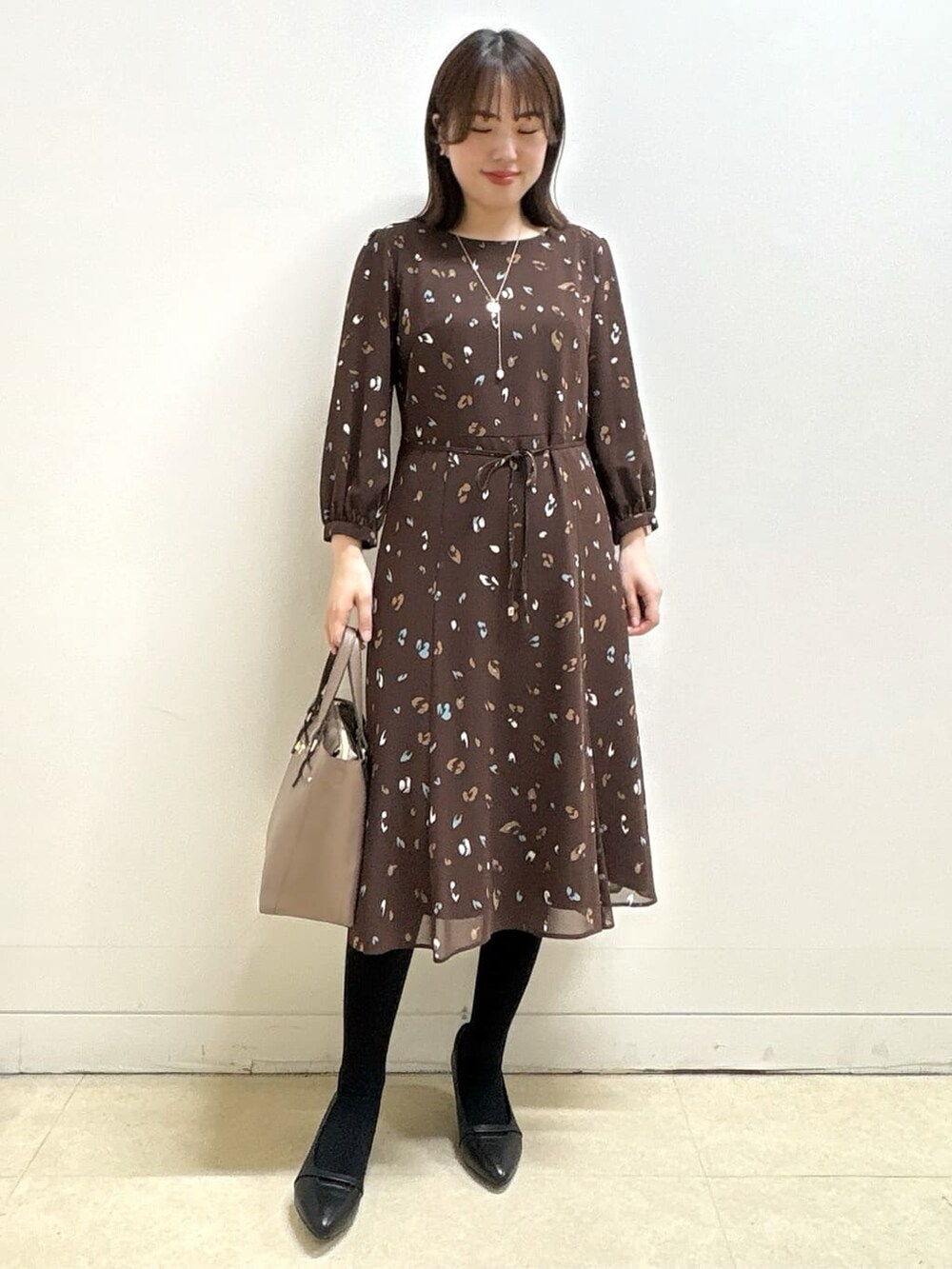 ブルー系のカーディガン/ボレロ、ブラウン系のワンピース、ブラック系のパンプスを着用したレディースの冬コーディネートの7枚目の写真