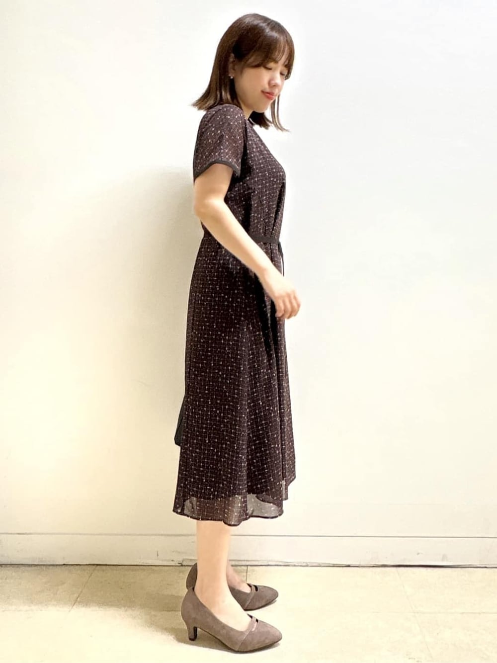 ブラウン系のワンピース、ベージュ系のパンプス、ブラック系のハンドバッグを着用したレディースの秋コーディネートの5枚目の写真
