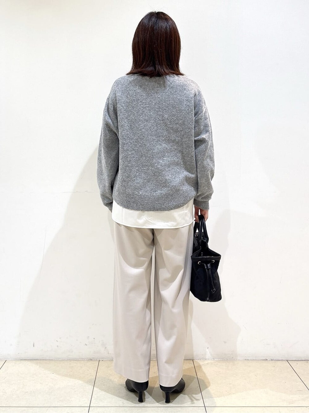 グレー系のニット/セーター、ホワイト系のTシャツ/カットソー、ベージュ系のその他パンツを着用したレディースの冬コーディネートの6枚目の写真