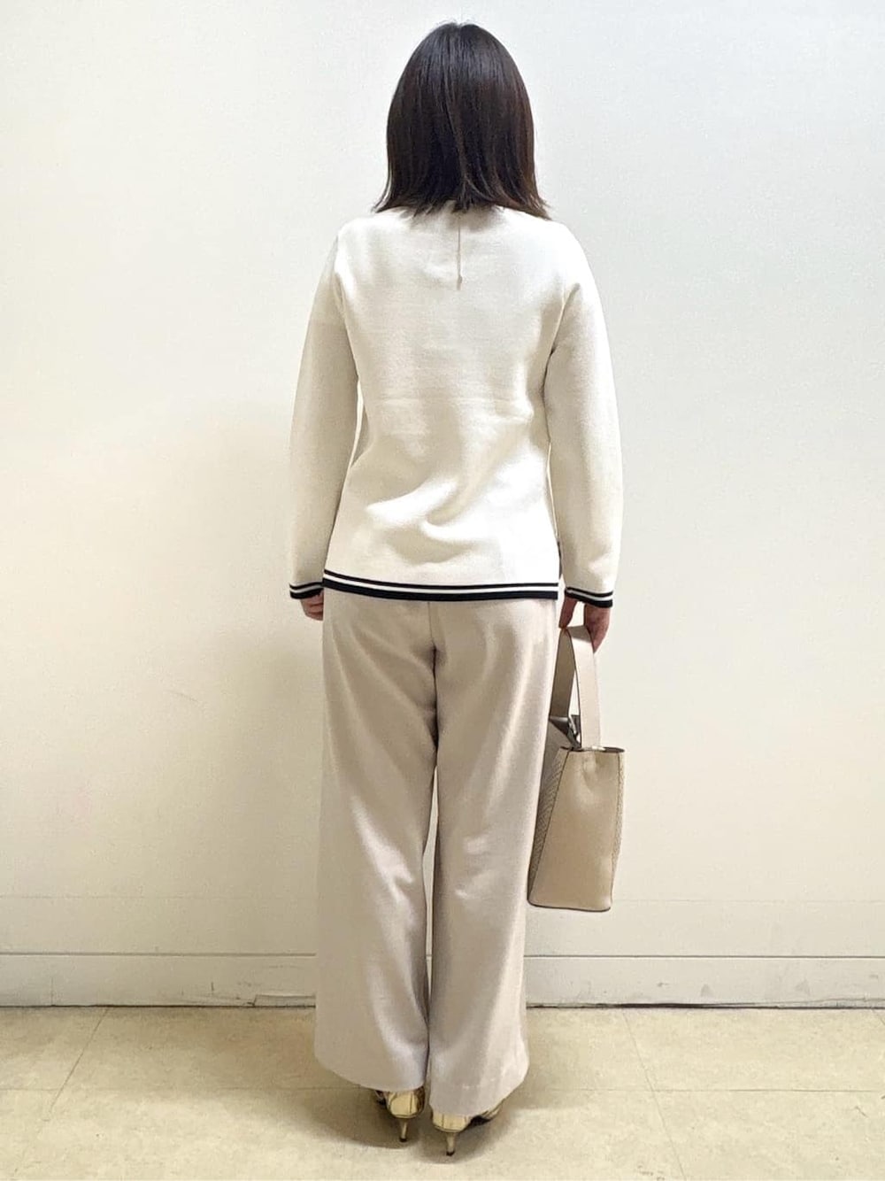 ベージュ系のその他パンツ、ホワイト系のニット/セーター、オレンジ系のカーディガン/ボレロを着用したレディースの冬コーディネートの5枚目の写真