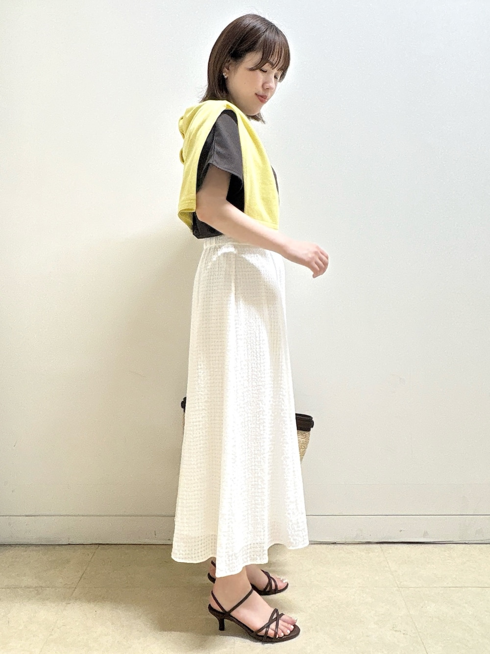 ブラウン系のTシャツ/カットソー、イエロー系のカーディガン/ボレロ、ホワイト系のスカートを着用したレディースの夏コーディネートの5枚目の写真