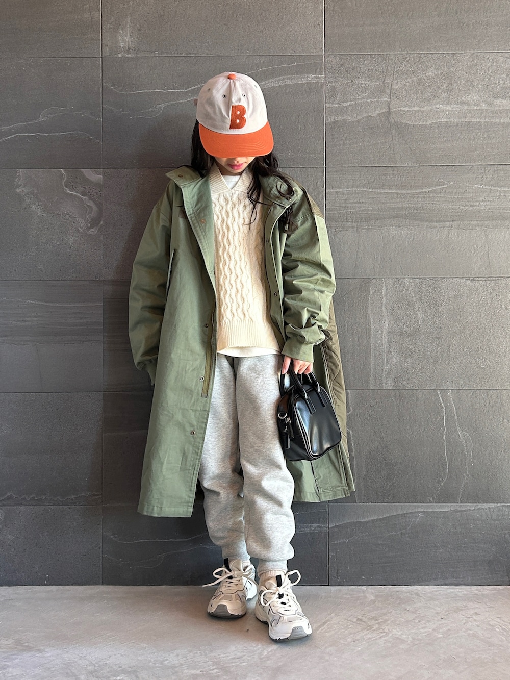 グリーン系のモッズコート、ベージュ系のニット/セーター、ホワイト系のTシャツ/カットソーを着用したキッズの冬コーディネートの4枚目の写真