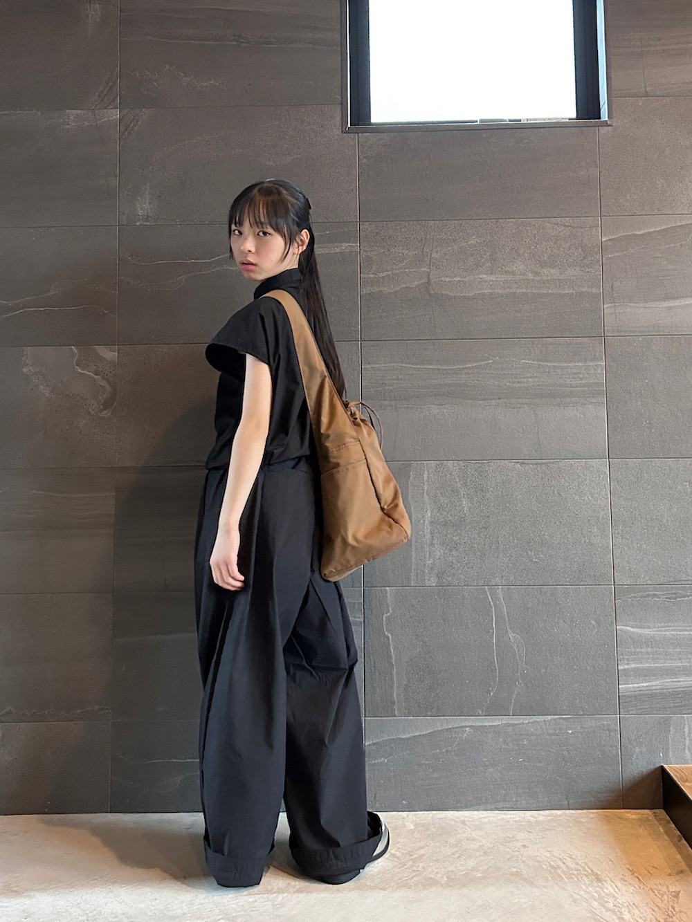 ブラック系のシャツ/ブラウス、ブラック系のパンツ、ブラウン系のショルダーバッグを着用したキッズの春コーディネートの4枚目の写真