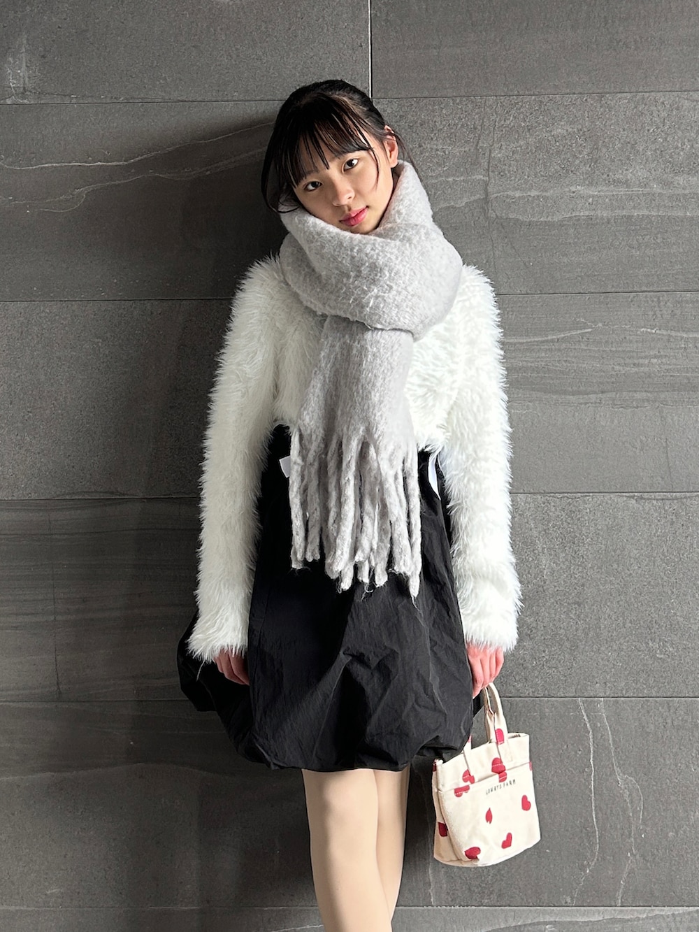 ホワイト系のカーディガン/ボレロ、ブラック系のスカート、ホワイト系のショルダーバッグを着用したキッズの冬コーディネートの3枚目の写真