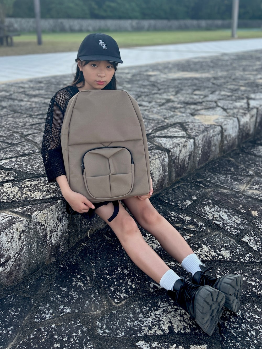 ブラウン系のバックパック/リュック、ブラック系のTシャツ/カットソー、ブラック系のデニムスカートを着用したキッズの夏コーディネートの2枚目の写真