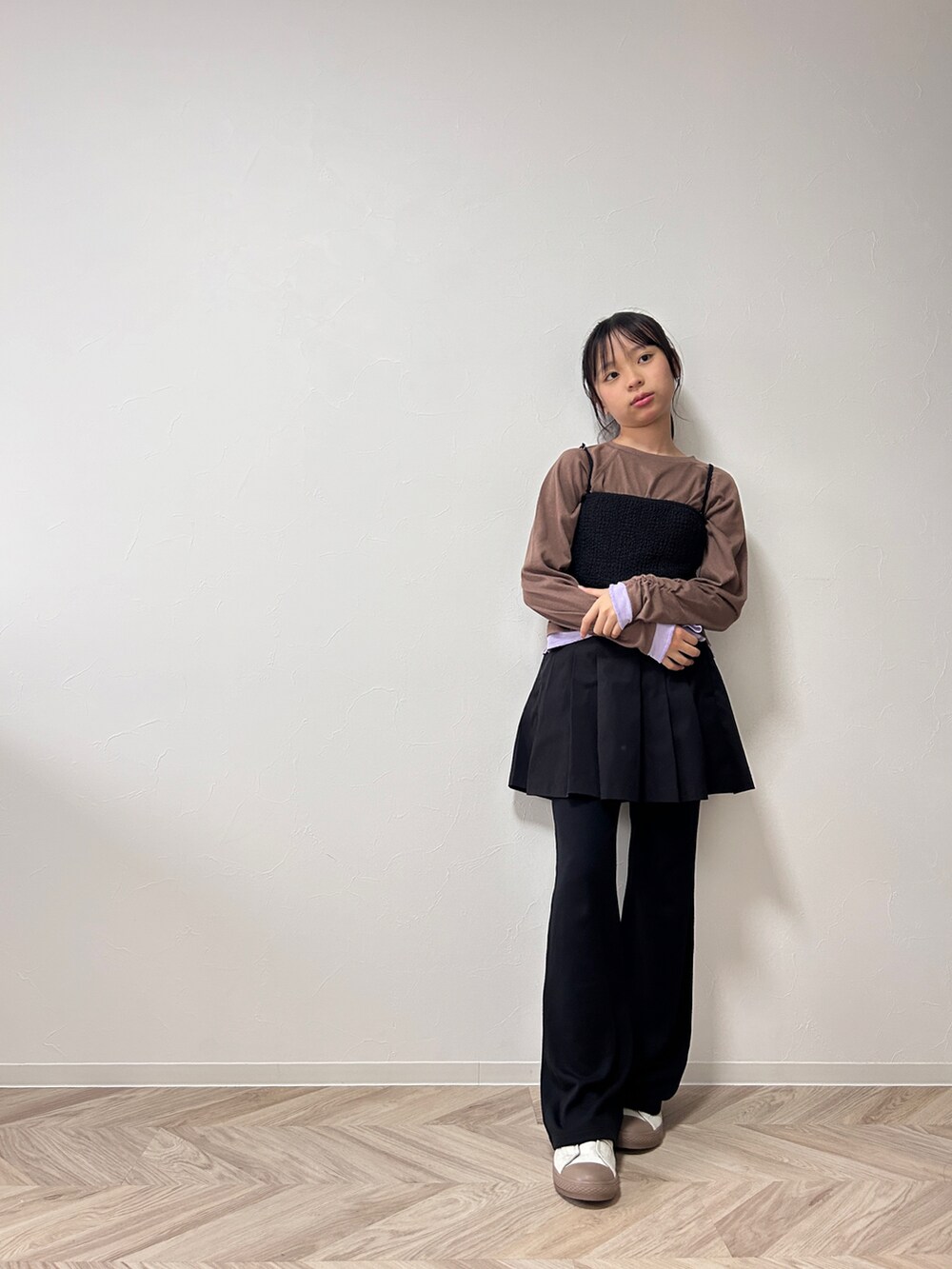 ブラウン系のTシャツ/カットソー、ブラック系のスカート、ベージュ系のスニーカーを着用したキッズの秋コーディネートの2枚目の写真