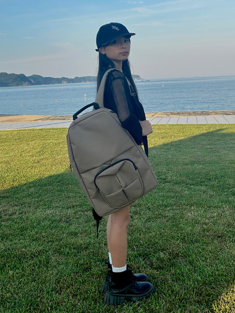 ブラウン系のバックパック/リュック、ブラック系のTシャツ/カットソー、ブラック系のデニムスカートを着用したキッズの夏コーディネートの4枚目の写真