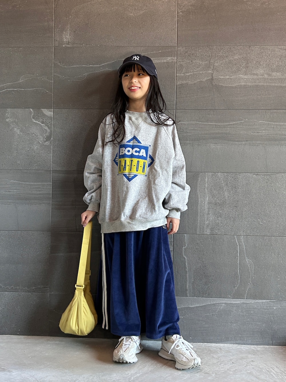 グレー系のスウェット、ブルー系のスカート、ホワイト系のスニーカーを着用したキッズの冬コーディネートの5枚目の写真