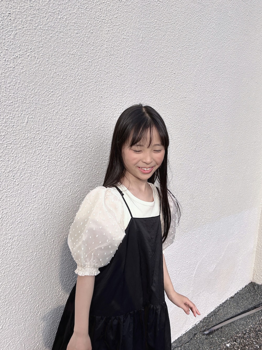 ホワイト系のシャツ/ブラウス、ブラック系のワンピース、ブラック系のサンダルを着用したキッズの春コーディネートの2枚目の写真