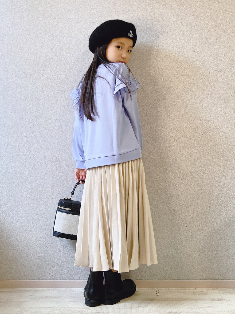 ブルー系のパーカー、ホワイト系のスカート、ブラック系のショルダーバッグを着用したキッズの夏コーディネートの2枚目の写真