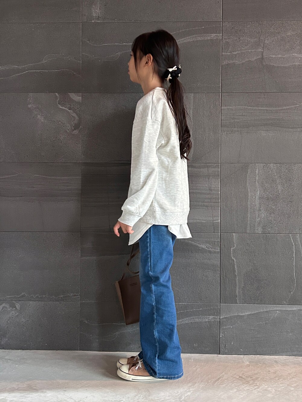 ベージュ系のスウェット、ブルー系のその他パンツ、ブラック系のその他ヘアアクセサリーを着用したキッズの秋コーディネートの2枚目の写真