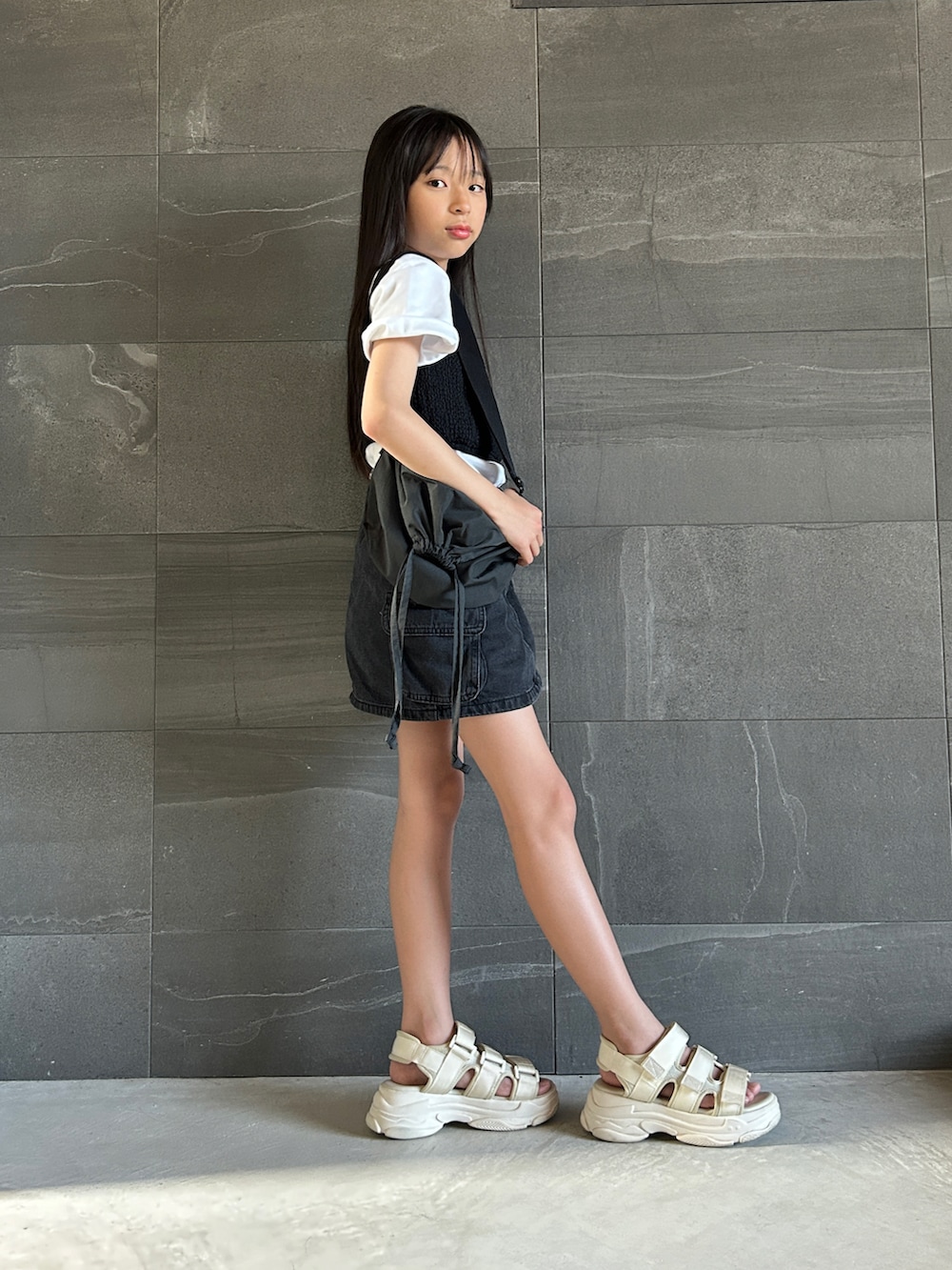 ホワイト系のTシャツ/カットソー、ブラック系のデニムスカート、ブラック系のチューブトップを着用したキッズの夏コーディネートの2枚目の写真