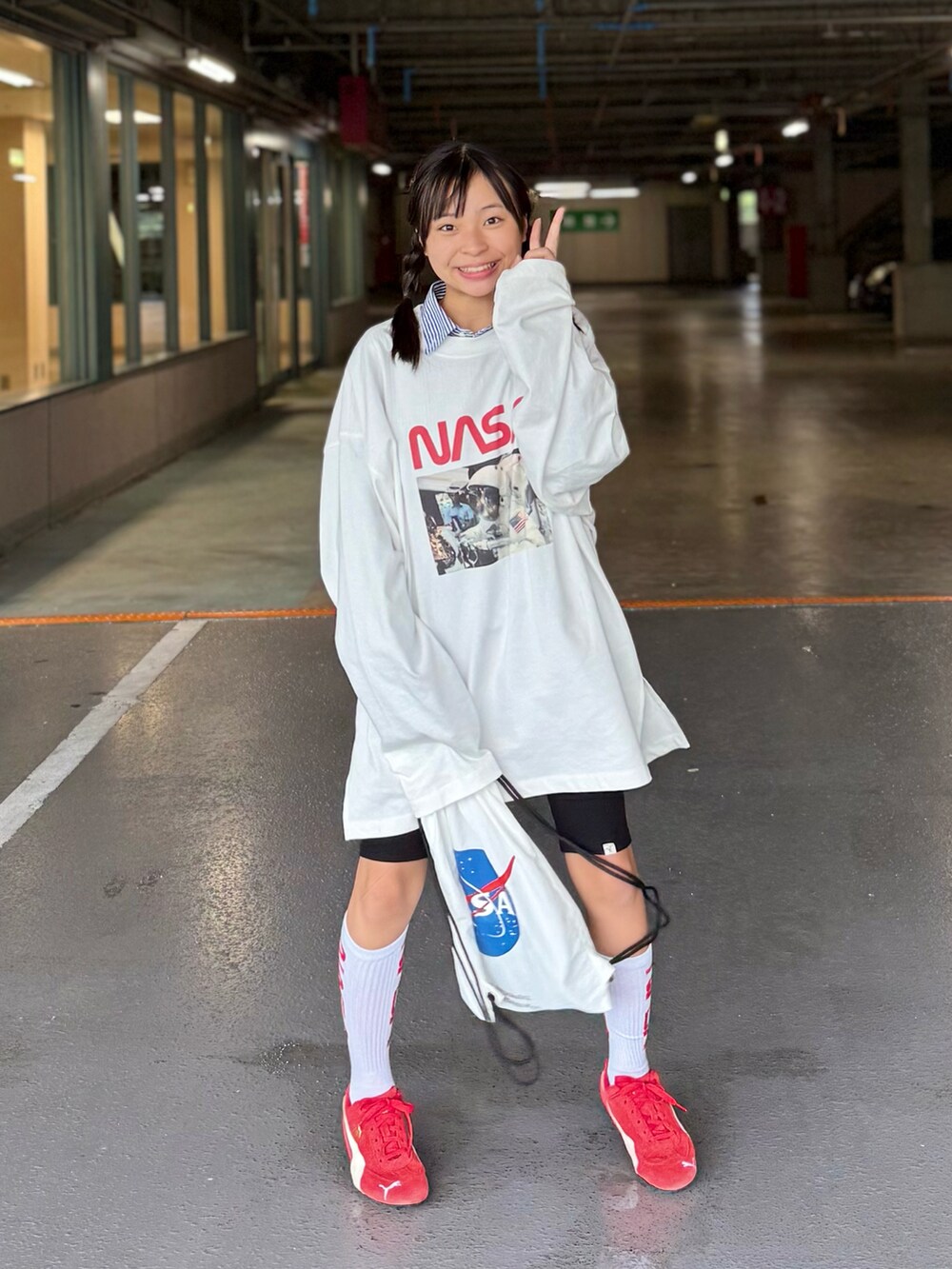 ホワイト系のTシャツ/カットソー、ホワイト系のバックパック/リュック、レッド系のスニーカーを着用したキッズの秋コーディネートの4枚目の写真