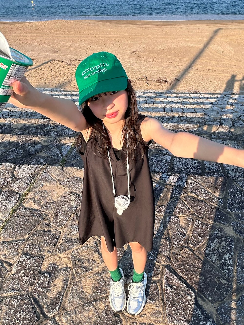 ブラック系のキャミソール、シルバー系のスニーカー、ブラック系の水着を着用したキッズの夏コーディネートの2枚目の写真