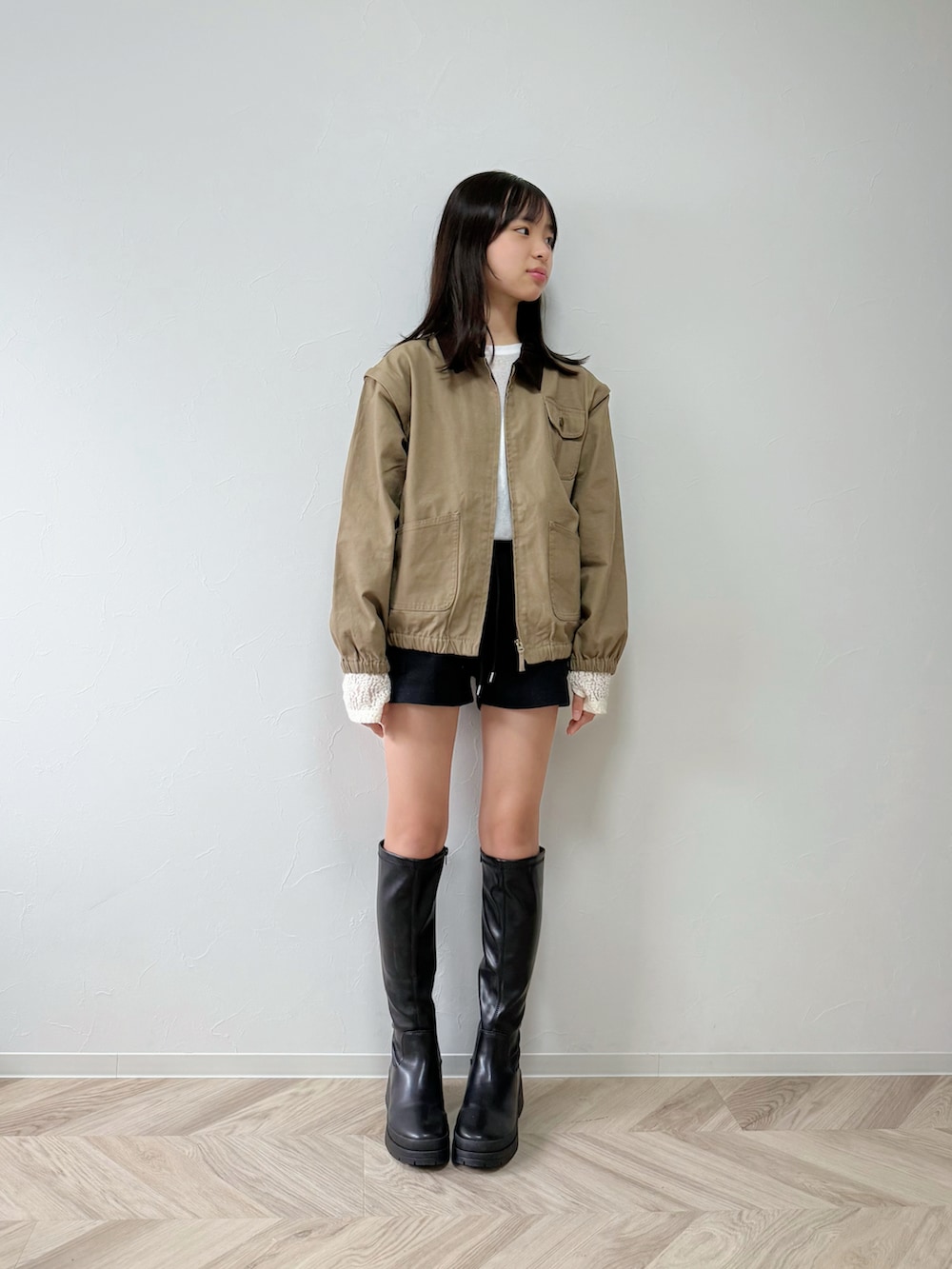 ホワイト系のTシャツ/カットソー、ベージュ系のブルゾン、ブラック系のブーツを着用したキッズの秋コーディネートの2枚目の写真