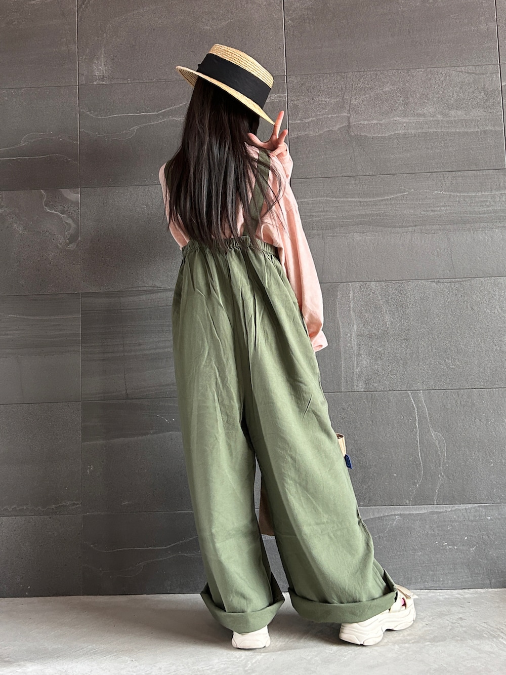 ピンク系のTシャツ/カットソー、グリーン系のサロペット/オーバーオール、ベージュ系のトートバッグを着用したキッズの冬コーディネートの3枚目の写真