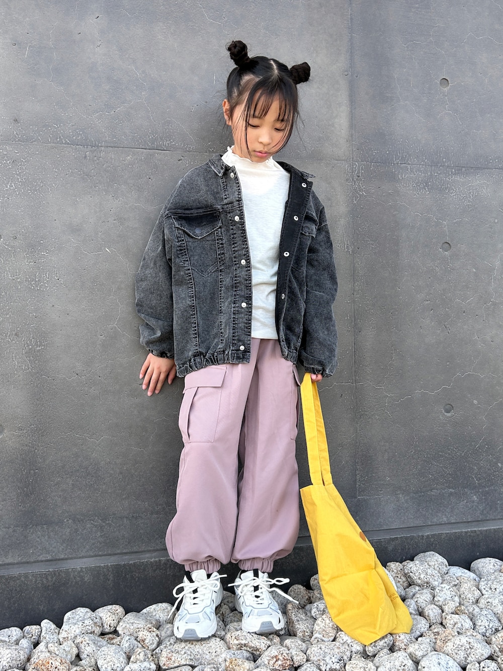 ブラック系のテーラードジャケット、グリーン系のカーゴパンツ、イエロー系のトートバッグを着用したキッズの春コーディネートの2枚目の写真