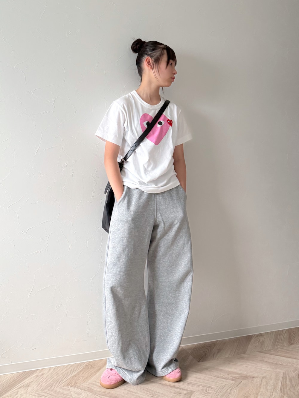 ピンク系のスニーカー、ブラック系のショルダーバッグ、ホワイト系のTシャツ/カットソーを着用したキッズの夏コーディネートの3枚目の写真