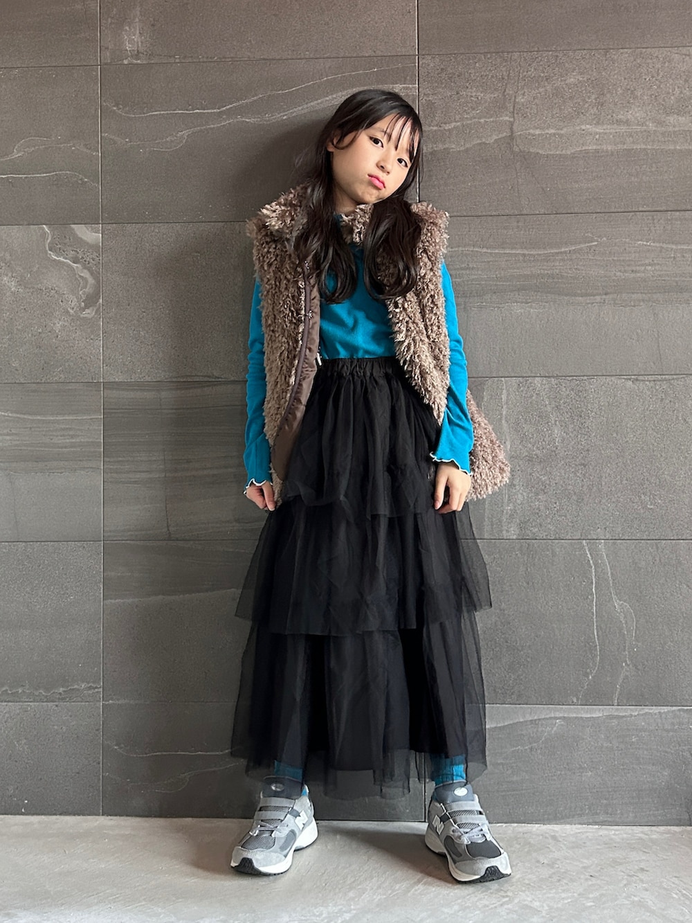 ブルー系のTシャツ/カットソー、ブラック系のスカート、ブラウン系のジャケット/アウターを着用したキッズの秋コーディネートの2枚目の写真