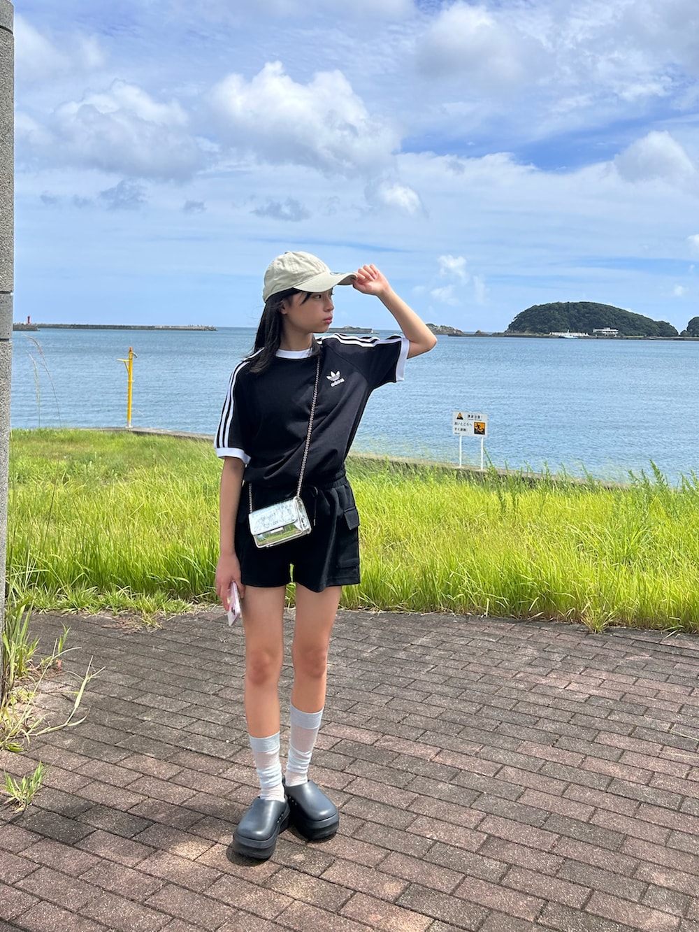 ブラック系のTシャツ/カットソー、ブラック系のサンダル、ベージュ系のキャップを着用したキッズの夏コーディネートの3枚目の写真